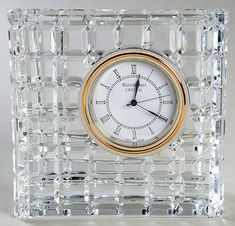 a clear glass clock with gold trim around the face