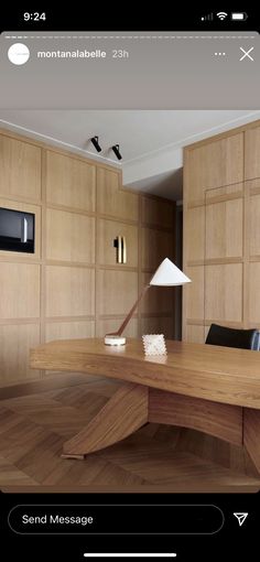 a wooden table with a lamp on top of it in front of wood paneled walls