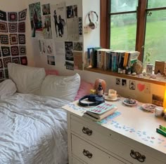 a bed room with a neatly made bed and lots of books on the dresser next to it