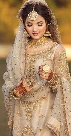 a woman wearing a bridal outfit and jewelry