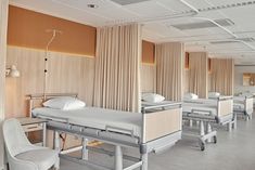 an empty hospital room with beds and chairs