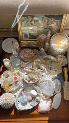 an assortment of seashells and candles on a table