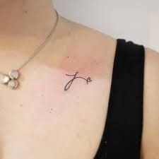 a woman with a small tattoo on her chest and the word faith written in cursive writing