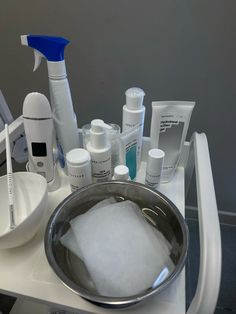 a bathroom sink filled with personal care items and cleaning products on top of the counter