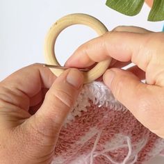 someone is working on some crafting with wood and yarn, while another person holds a pair of scissors in their hand