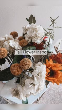 a vase filled with lots of white and orange flowers