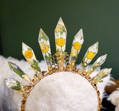 a tiara with yellow flowers on it sitting on top of a white fur pile