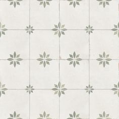 a white tiled floor with green leaves on the top and bottom tiles in different sizes