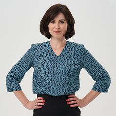 a woman with her hands on her hips posing for the camera in front of a white background