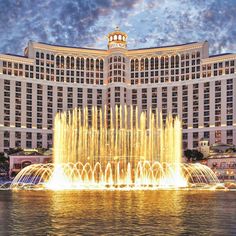 the fountains are lit up in front of the hotel