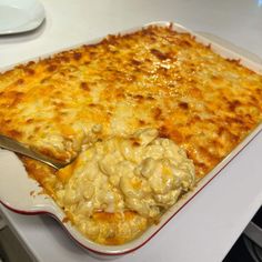 a large casserole dish with cheese and chicken in it on a white table