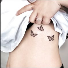 a woman's stomach with three butterflies on her side and the bottom part of her belly