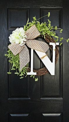 a black door with a wreath on it and the letter n in front of it