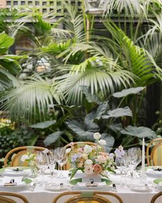 the table is set with flowers and place settings