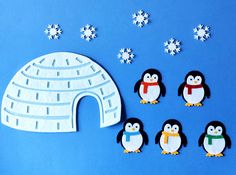 penguins are standing next to an igloose and snowflakes