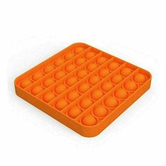 an orange plastic tray with lots of balls in it on top of a white background