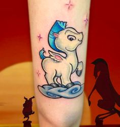 a unicorn tattoo on the leg of a person with a horse and stars in the background