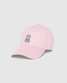 The MENS CLASSIC BASEBALL CAP - B6A816A1HT by Psycho Bunny is a timeless light pink baseball cap, meticulously crafted from 100% cotton, and showcased against a plain background. It features an embroidered design on the front, depicting a white bunny head with crossbones underneath. The bunny sports pink ears and black outlines, imparting a playful touch to this classic accessory. Spring Sports Baseball Cap, Six-panel, Pink Casual Snapback Hat For Baseball Season, Casual Pink Snapback Hat For Baseball Season, Trendy Snapback Hat For Baseball Season, Trendy Snapback Hat With Curved Bill For Sports, Spring Baseball Cap For Sports Events With Curved Bill, Casual Baseball Cap For Spring Sports Events, Spring Sports Baseball Cap With Curved Bill, Spring Casual Baseball Cap For Sports Events