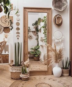 a mirror sitting on top of a wooden table next to plants and potted plants