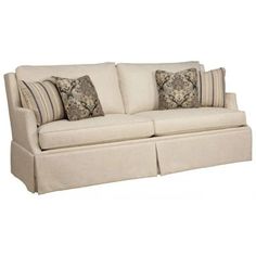 a white couch with pillows on it and two throw pillows in front of the couch