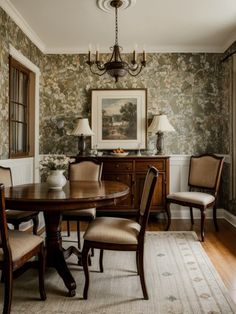 a dining room table with four chairs and a chandelier hanging from the ceiling