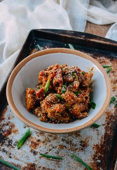 a bowl filled with food sitting on top of a metal tray next to a napkin