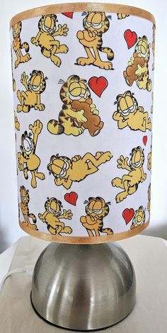 a lampshade with cartoon characters on it sitting on top of a metal base