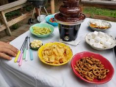 a table topped with bowls filled with food next to an ice cream sundae cake