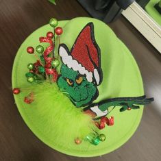 a green hat with an elf's head on top of it and christmas decorations