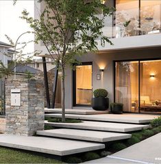 a modern house with stone steps leading up to the front door