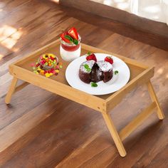 two desserts are sitting on a wooden tray