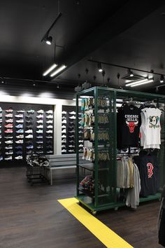 the inside of a clothing store with lots of t - shirts on display