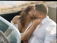 a man and woman kissing in the back of a car