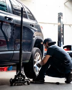 a man working on the tire of a car