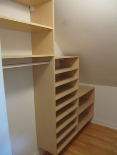 an empty closet is shown with shelves and shelving unit in the corner, along with hard wood flooring