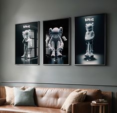 three black and white pictures hang on the wall above a couch