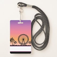 a luggage tag with a ferris wheel in the background and palm trees around it on a lanyard