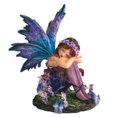 a fairy figurine sitting on top of a rock