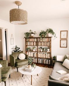 a living room filled with lots of furniture and bookshelves covered in plants on top of them