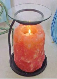 a candle that is sitting on top of a glass table next to a blue bag