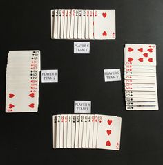 several playing cards are arranged on a black table with red and white hearts in them