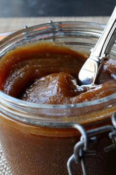 a spoon in a jar filled with caramel sauce