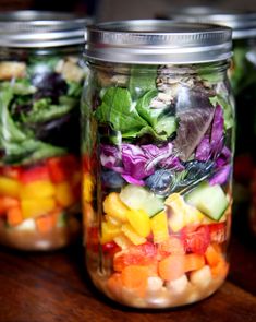 four mason jars filled with different types of salads and veggies in them