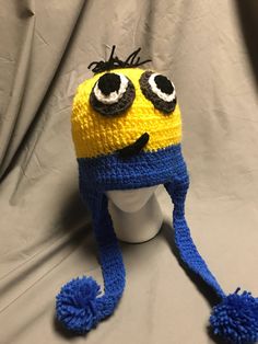 a crocheted hat with googly eyes and a pom - pom