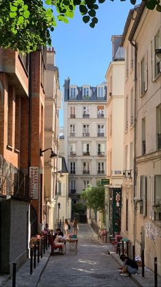 people sitting on benches in an alley between two buildings