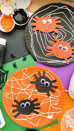 paper plates decorated to look like children's halloween crafts with spider, crab and web on them