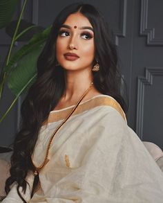 a woman with long black hair wearing a white sari