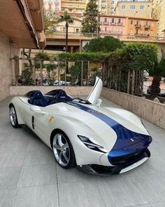 a white and blue sports car parked in front of a building