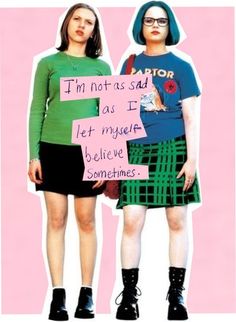 two women standing next to each other in front of a pink and green poster with words written on it