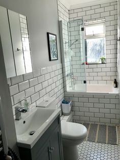 a bathroom with white and gray tiles on the walls